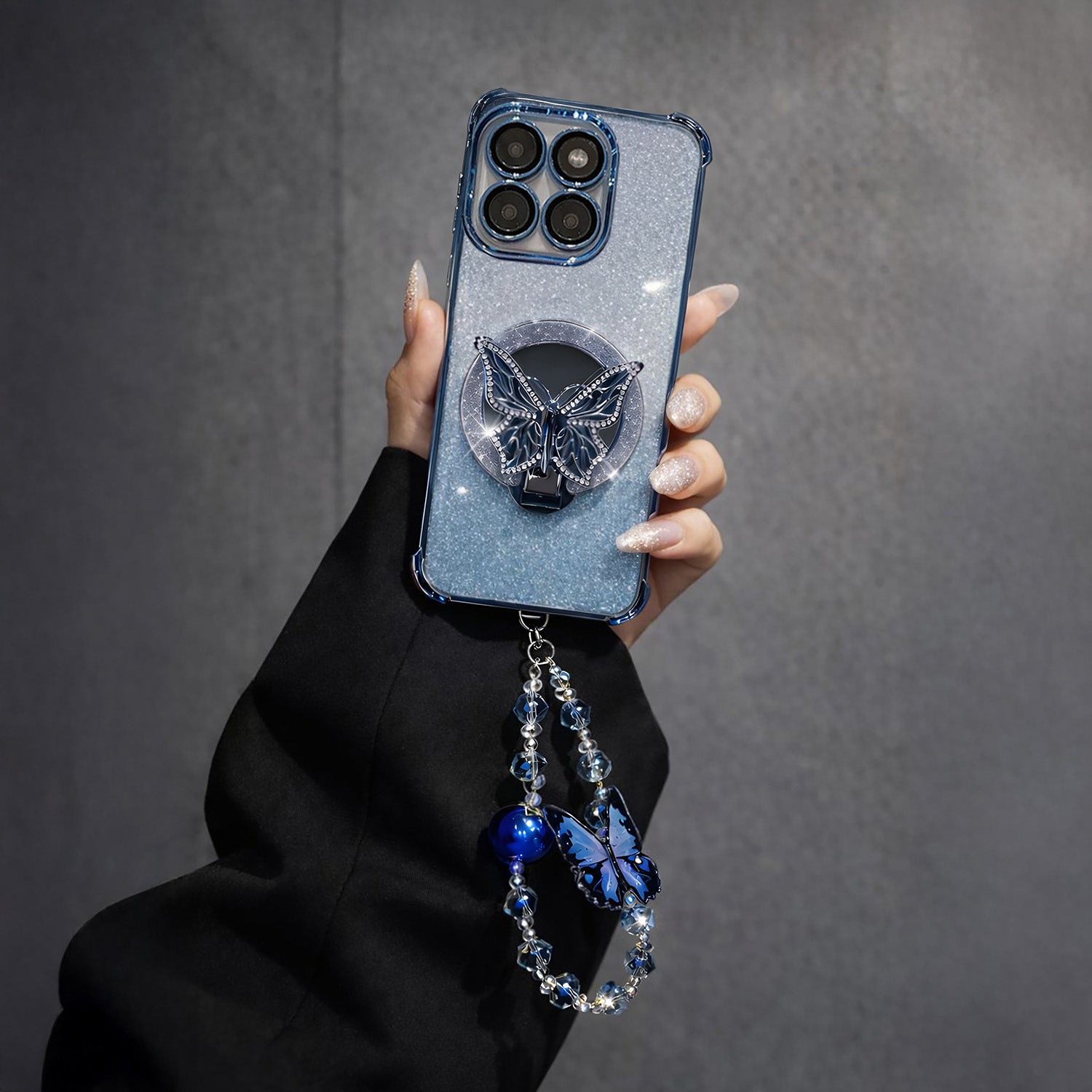Motorola Edge 60 Pro 5G Phone case with butterfly design and dangling charm held by a hand against a gray background