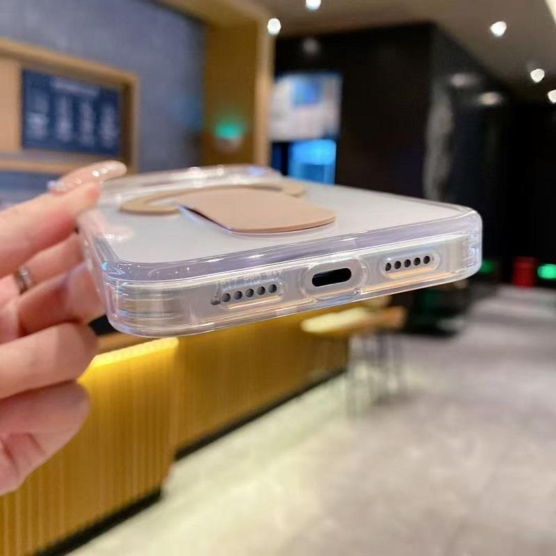 Clear phone case with brown accent held by a hand in an indoor setting
