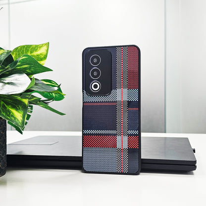 Phone case with plaid pattern on a white surface with a plant in the background